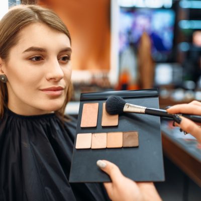 visagiste-and-lady-chooses-cosmetic-in-makeup-shop.jpg